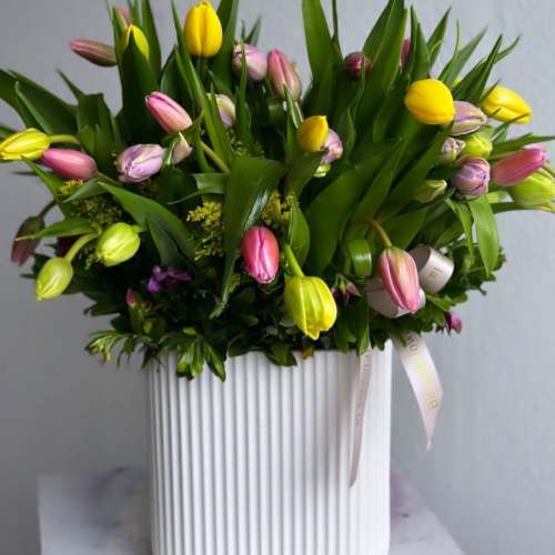 Mixed tulip bouquet in a white ribbed vase