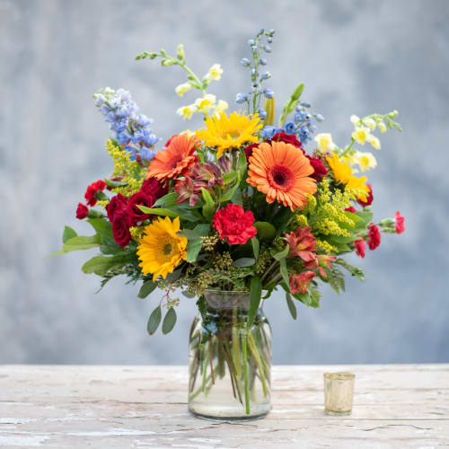Mixed bouquet of bright flowers in a clear glass vase