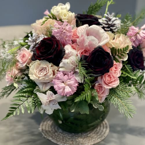 Mixed pink and white flowers in a green glass vase