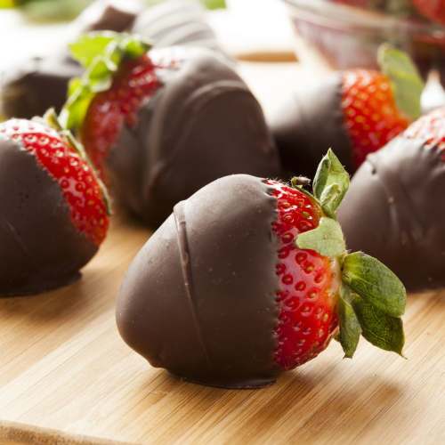 Chocolate-dipped strawberries on a wooden surface