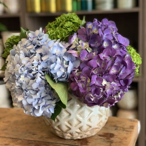 Blue and purple hydrangeas in a patterned ceramic vase