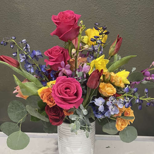Colorful mixed bouquet in a white vase with roses and tulips