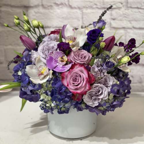 Bouquet of pink, purple, and white flowers in a white vase