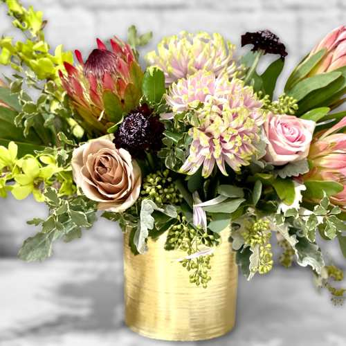 Mixed bouquet in a gold vase with pink and green flowers
