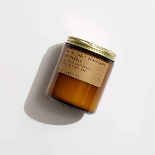 Amber jar candle with a gold lid and paper label