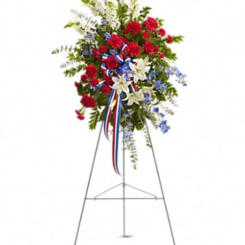 Standing floral spray with red, white, and blue flowers on an easel