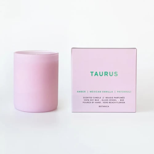 Pink scented candle in a glass vessel beside its box