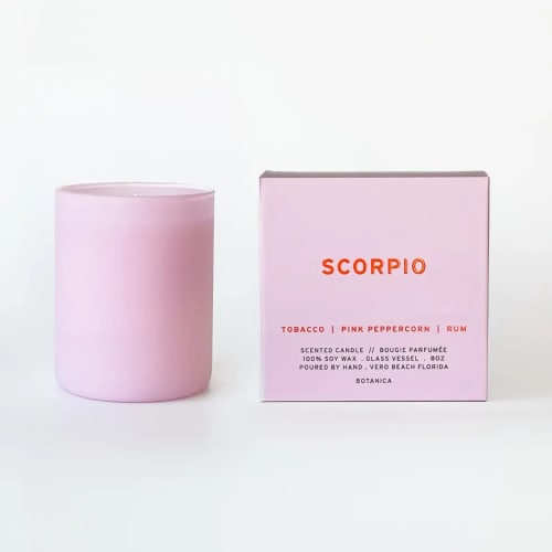 Pink scented candle in a glass vessel beside its box