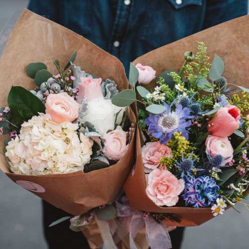 Two pastel mixed bouquets wrapped in brown paper