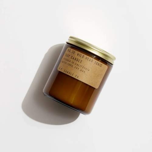 Amber jar candle with a gold lid and kraft label