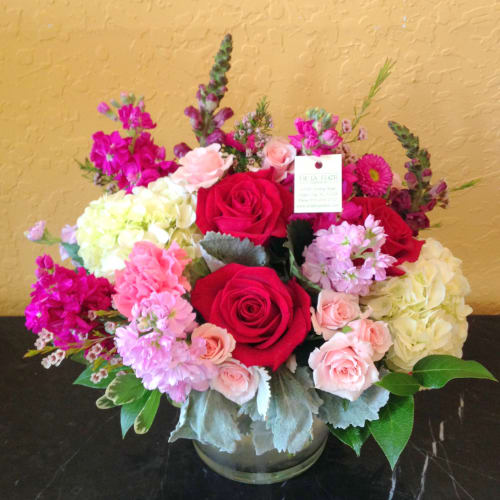 Bouquet of red and pink roses with hydrangeas in a glass vase