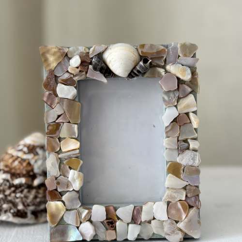 Decorative photo frame covered in shell pieces