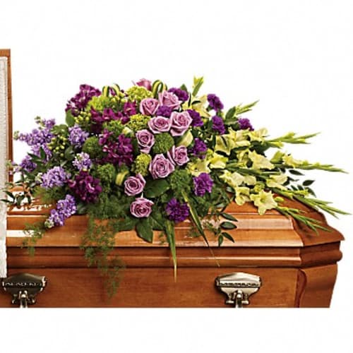 Purple and yellow floral spray on a wooden casket