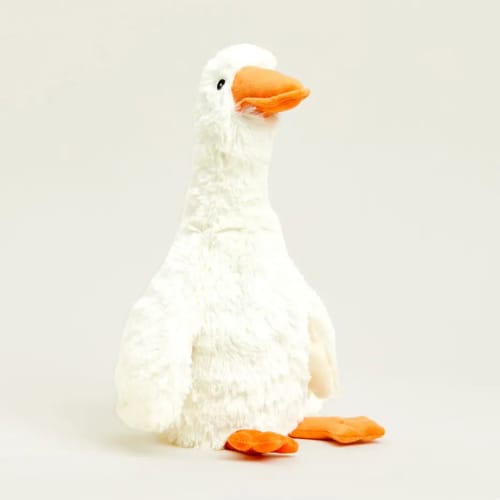 White plush duck with an orange beak and feet on a plain background