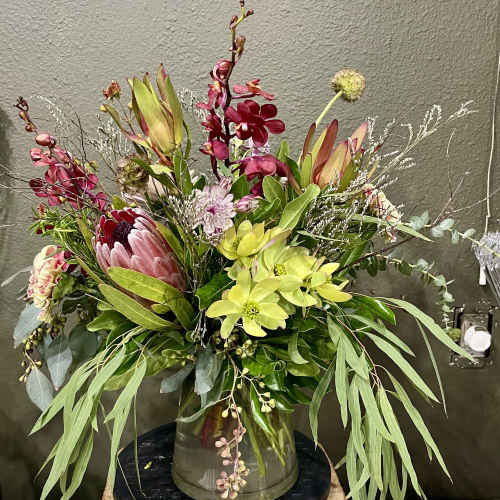 Mixed bouquet with pink and green flowers in a glass vase