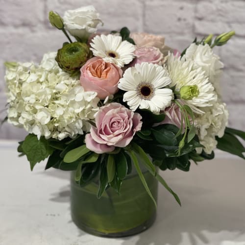 Pink roses and white daisies in a green glass vase
