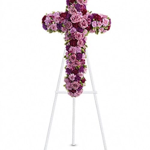 Cross-shaped floral tribute on a white easel