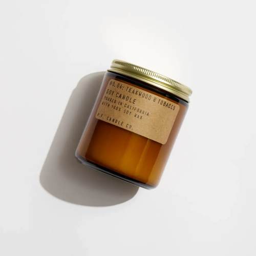Amber jar candle with a gold lid and paper label