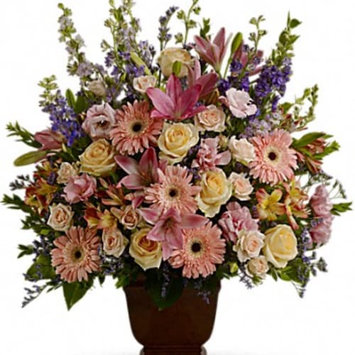 Mixed pink and cream flowers in a brown urn vase