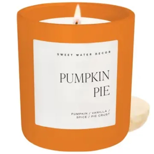 Orange pumpkin pie scented candle in a glass jar