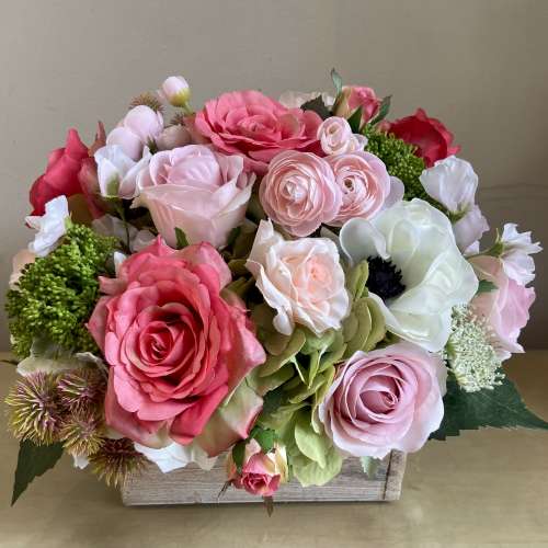 Pink and white rose arrangement in a wooden box