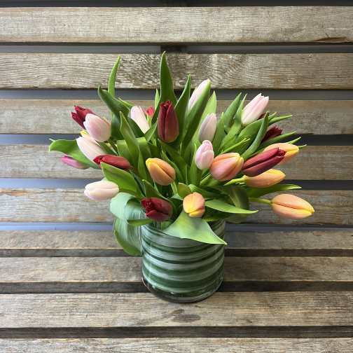 Mixed tulips in a striped glass vase
