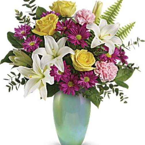 Bouquet of white lilies, yellow roses, and purple daisies in a green vase