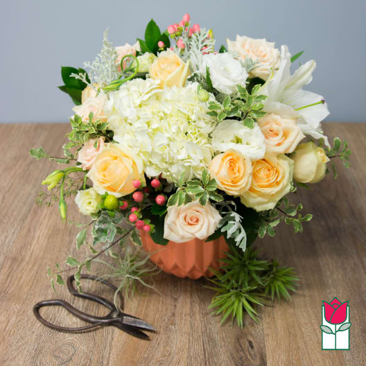 Peach and white rose bouquet in a peach vase