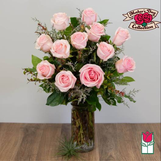 Pink roses arranged in a tall glass vase