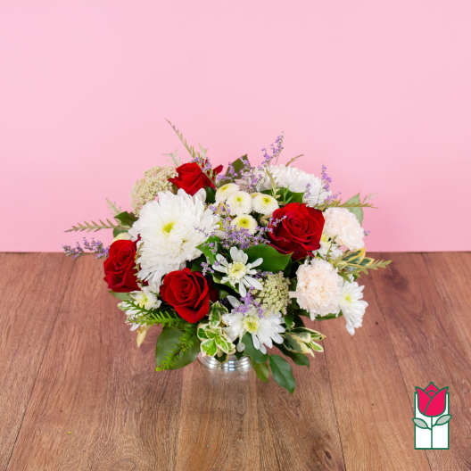 Bouquet of red and white flowers in a low silver vase
