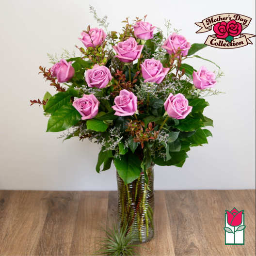 Pink roses arranged in a tall glass vase