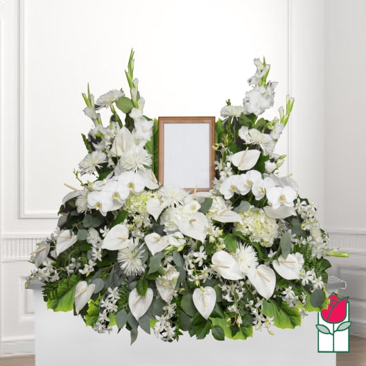 White floral funeral spray with a framed photo holder in the center