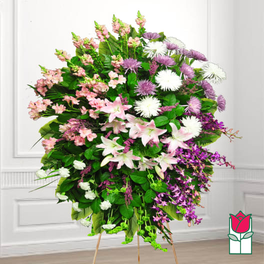 Large standing spray of pink, white, and purple flowers on an easel