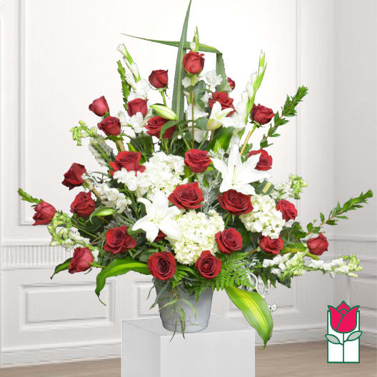 Red roses and white lilies arranged in a gray vase