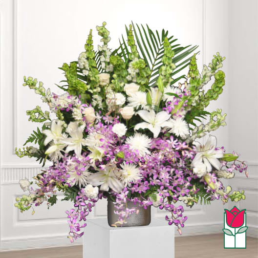 White lilies and purple orchids in a silver vase