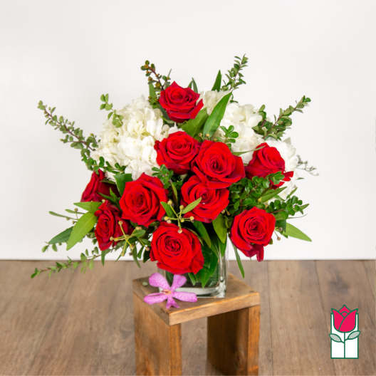 Red roses and white hydrangeas in a clear glass vase