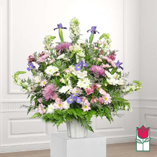 Mixed bouquet in a white vase with purple irises and pink and white daisies