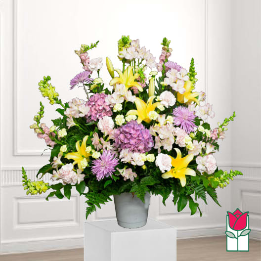 Large mixed bouquet in a gray vase with yellow lilies and pink flowers