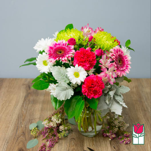 Mixed bouquet in a glass vase with pink gerberas, white daisies, and carnations