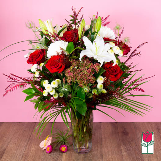 Bouquet of red roses and white lilies in a clear glass vase