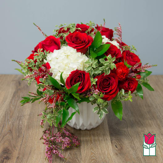 Red roses and white hydrangea in a white vase