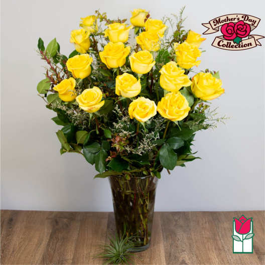 Yellow roses arranged in a tall glass vase