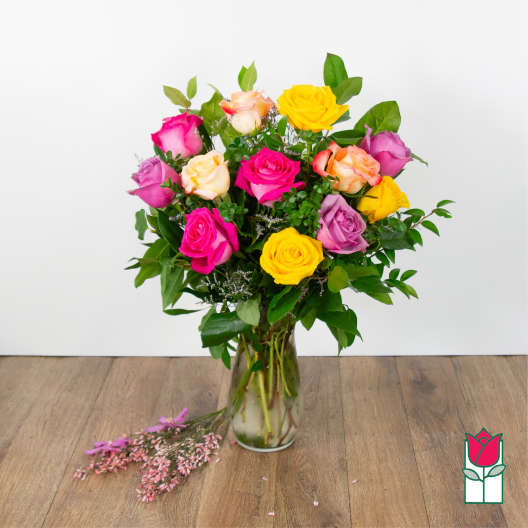 Mixed roses in a clear glass vase with pink and yellow blooms