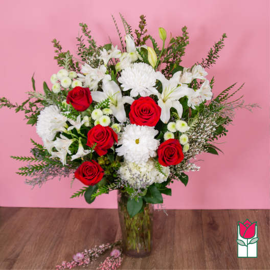 Bouquet of red roses and white lilies in a glass vase