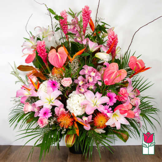 Large tropical bouquet with pink lilies, orchids, and anthuriums in a black vase