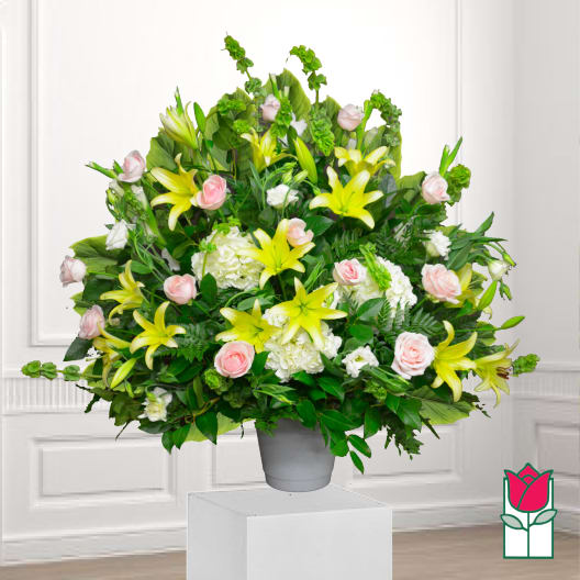 Large bouquet of yellow lilies and pink roses in a gray vase