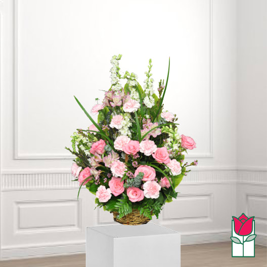 Pink roses and carnations in a wicker basket arrangement
