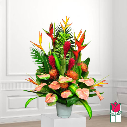 Tropical flower arrangement with orange heliconia and pink anthuriums in a gray pot