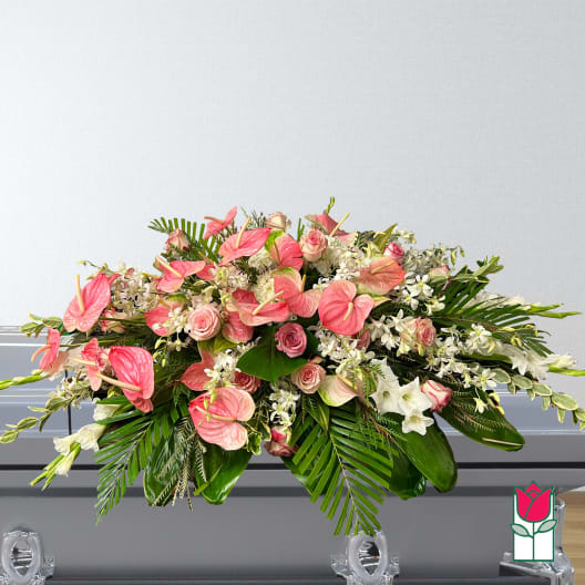 Large pink and white floral arrangement with tropical leaves