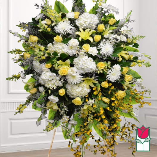 Large standing spray of white and yellow flowers on a wooden easel